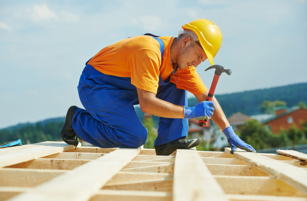 En man snickrar på taket