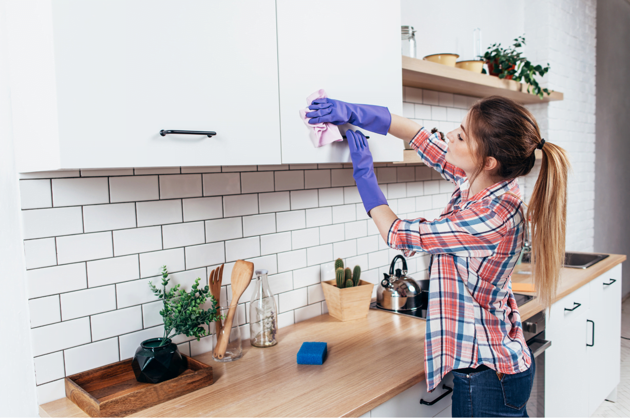 Woman cleaning kitchen cabinets for Ongoing Home Cleaning